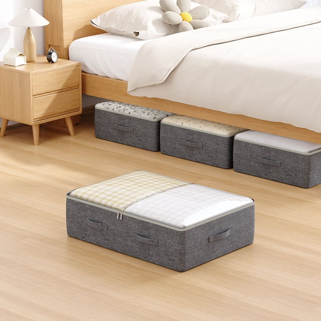 Underbed Storage Bag for household clothes and quilts, shown in a grey cationic fabric with reinforced handles and a zippered top. The bag measures 18.5 x 10.63 x 7.87 inches and is designed for efficient storage under the bed. It features a sturdy steel frame and medium-density fiberboard base for durability and stackability. The image shows multiple storage bags neatly placed under a wooden bed in a tidy bedroom setting.