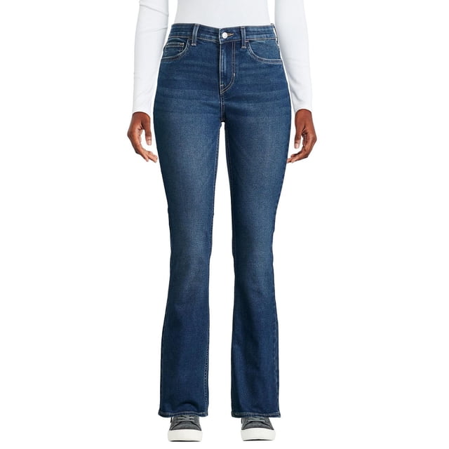 George women's boot leg jean in dark blue stretch denim with slim fit through hip and thigh, sitting just below the waist, featuring button and zipper fly closure, belt loops, and 5-pocket design, shown front-facing on a model wearing grey sneakers and a white long-sleeve top.