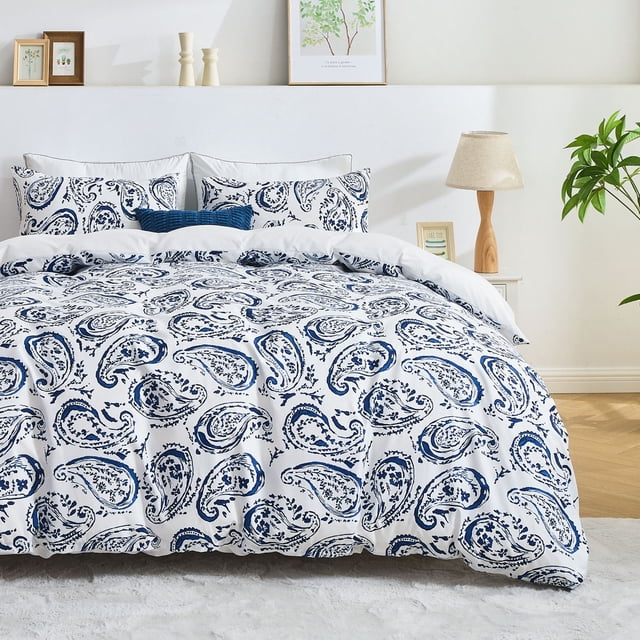 Hitime Queen Duvet Cover Set, made from ultra-soft and breathable microfiber fabric with reinforced stitching for durability. Features a blue and white paisley pattern, perfect for queen-sized beds. Includes one duvet cover and two pillowcases, ideal for all seasons. Displayed in a bright, modern bedroom with framed artwork and a bedside lamp.