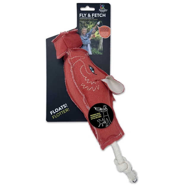 Spunky Pup Jouet pour Chien Fly & Fetch à Lancer en Tissu Rouge avec Détails Brodés d'Oeil et de Bouche et une Queue en Corde Nouée Blanche, Conçu pour Flotter et Se Lancer jusqu'à 100 Pieds à l'Aide d'Un Cou Élastique, Affiché sur un Emballage Noir avec des Informations sur le Produit et une illustration d'Utilisation.