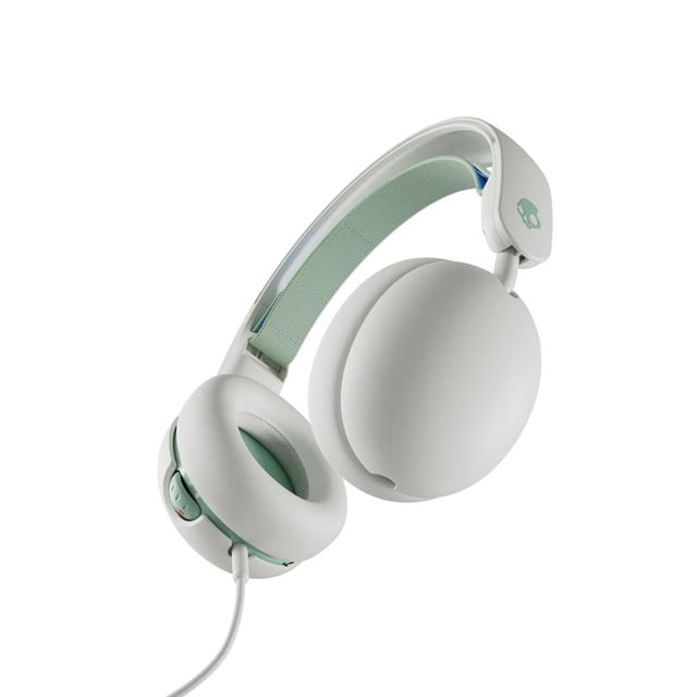Skullcandy Grom Over-Ear Sound Isolating Kids Headphones in bone seafoam colour, featuring adjustable suspension headband with seafoam fabric padding, soft over-ear cushioned earcups, volume limited to 85 decibels, wired 3.5mm audio jack, built-in microphone, share audio port for multi-kid listening, and collapsible travel-ready design.