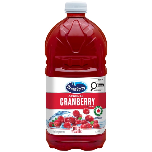 Ocean Spray Cranberry Cocktail in a 1.89 L plastic bottle with a white cap, featuring a red label with cranberries and water splash graphics, highlighting 100% vitamin C and Canadian ingredients, often enjoyed mixed with sparkling water.