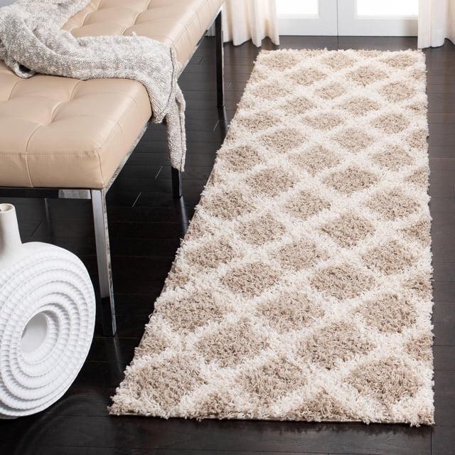 Safavieh Dallas Jerrie Tapis Shag Géométrique pour Aire avec Motif Losanges beige et Crème et texture Shag dense sur Plancher de Bois Franc Foncé à Côté d'Un Banc Capitonné beige avec Pattes en Métal et Jeté Tricoté, Rideaux Blancs Près et un vase en Céramique Blanc, Idéal pour les Zones à Fort Passage.