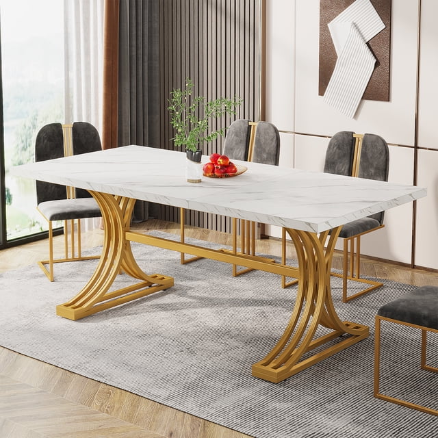 Fnova 63" Modern Dining Table featuring a rectangular white faux marble top and stylish gold metal trestle legs. The table is set in a contemporary dining room with grey upholstered chairs and a decorative centerpiece. Measuring 31.50" D x 62.99" W x 29.53" H, it seats 4 to 6 people, ideal for family meals or gatherings. The smooth, waterproof tabletop is easy to clean, and the durable metal legs provide stability with adjustable feet for uneven floors.