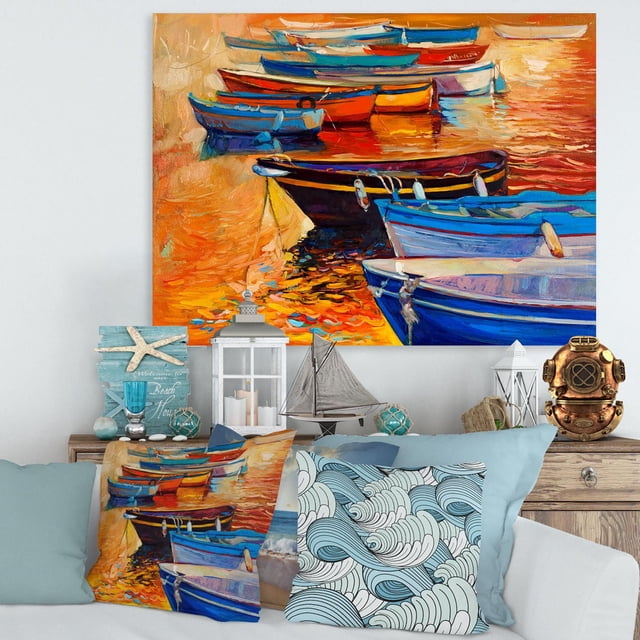 Designart Boats In The Harbor During Warm Colourd Sunset I Canvas Wall Art featuring a gallery-wrapped cotton canvas print of colorful boats in a harbor with vivid orange and blue hues, stretched over a wooden frame, displayed above a coastal-themed living room with matching nautical pillows, lanterns, and decorative sailboat, ideal for adding a coastal vibe to home décor.