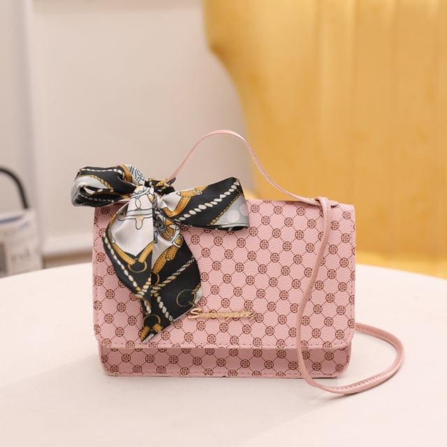 Vaidha One Shoulder Crossbody Bag Leather Large Capacity Multi Compartment Women Bag in a soft pink color with a patterned design and a decorative scarf tied to the strap. This stylish shoulder bag features a spacious interior with multiple compartments, ideal for storing daily essentials like a smartphone, money, and cosmetics. Perfect for events, travel, or casual outings. Positioned on a white surface with a blurred yellow background.