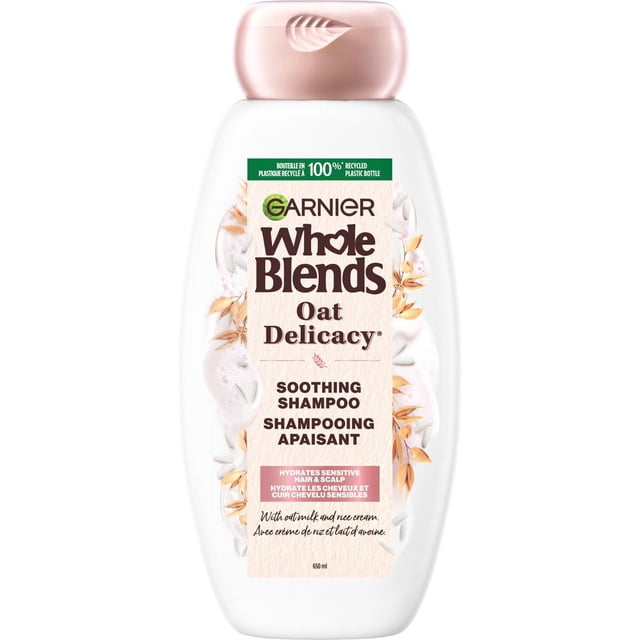 Garnier Whole Blends Shampooing, Délicatesse à l'Avoine, Bouteille Blanche de 650 ml avec Capuchon Rose Pâle, Présentant des illustrations d'Avoine et de Crème de Riz, Étiqueté comme Shampooing Apaisant Qui Hydrate les Cheveux et le Cuir Chevelu Sensibles avec des Extraits de Lait d'Avoine et de Crème de Riz.