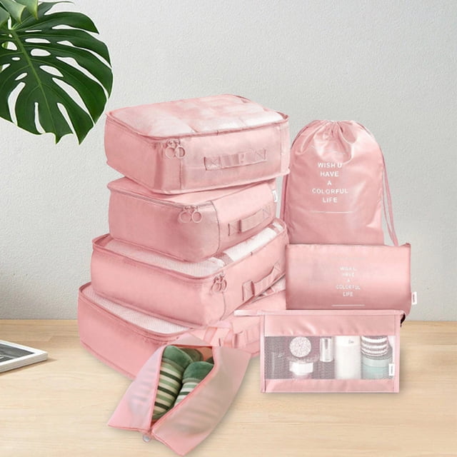 LSLJS Packing Cubes 8 Sets Travel Luggage Organizers in a soft pink color, including various sizes of pouches and bags. The set features a shoe storage bag, mesh compartments for visibility, and double zippers for easy access. Displayed on a wooden surface with a minimalist background, these polyester organizers are ideal for travel, camping, and home storage.