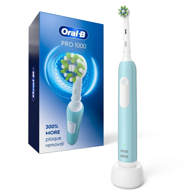 Oral-B Pro 1000 Electric Toothbrush in turquoise with CrossAction brush head on white charging base next to blue box showing toothbrush and 300% more plaque removal claim along gumline