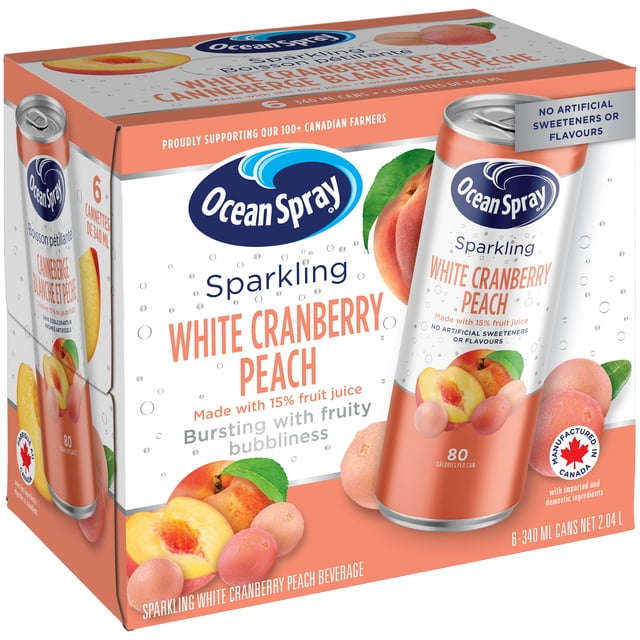 Ensemble de Six Canettes de 340 ml de Canneberge Blanche et Pêche Scintillante par Ocean Spray, Faites avec 15 % de Vrai Jus de Fruits et Sans Édulcorants Ni Arômes Artificiels. l'Emballage Soutient les Agriculteurs Canadiens et Présente des images de Canneberge Blanche et de Pêche sur une Boîte Blanche et de Couleur Pêche, Convient aux Buveurs d'Eau Scintillante à la Recherche d'Une Boisson Fruitée Naturelle.