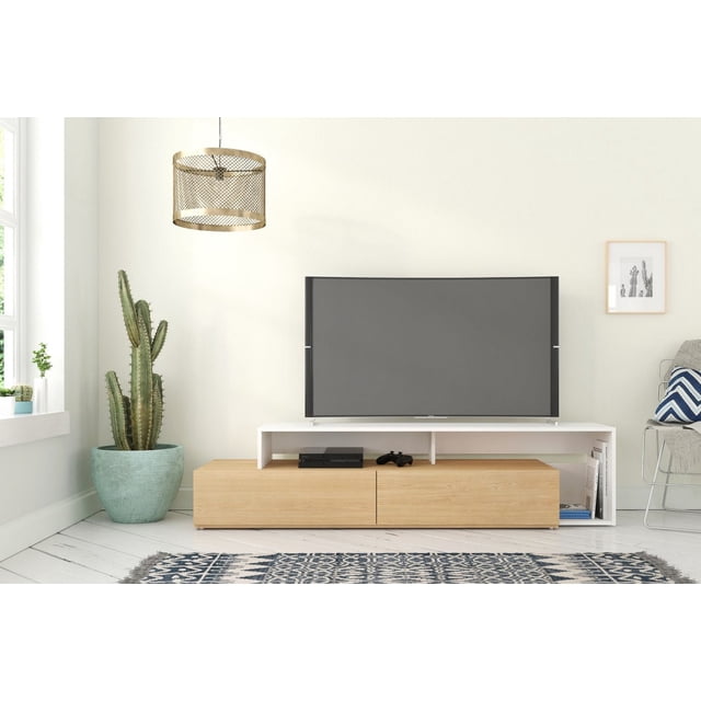 Nexera Tonik Meuble Télé de 72 Po, Blanc, Orienté vers l'Avant avec un Cadre Blanc et des Tiroirs en Bois Naturel, avec des Compartiments Centraux Ouverts Tenant une console de Jeu et une Manette, Deux Tiroirs de Rangement et des Étagères Latérales avec des Livres, Posé sur un Plancher de Planches Blanches avec un Tapis à Motif Bleu et Blanc, à Côté d'Un Grand cactus Vert dans un pot turquoise et sous une Suspension Tressée.
