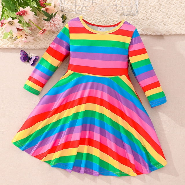 Nrmrqzzcjnd pour la Maison Robe Arc-en-Ciel à Manches Volantées pour Enfants, Robe à Manches Longues à Col Rond pour Filles avec des Rayures Arc-en-Ciel Vibrantes, Conçue pour 3-7 Ans. Fabriquée en Coton Doux et Agréable pour la Peau, Cette Robe Présente une Jupe Évasée et des Manches Volantées, Idéale pour les Fêtes, les Voyages Ou les Tenues Décontractées. Exposée sur une surface beige avec des accents Floraux et une Décoration Papillon.