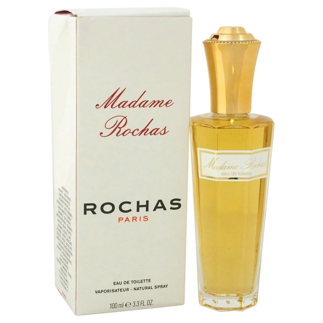Madame Rochas by Rochas for Women - 3.4 oz EDT Spray. A timeless floral fragrance launched in 1960, combining delightful flowers and exotic woods. The image displays the sophisticated glass bottle with a gold cap next to its branded box.