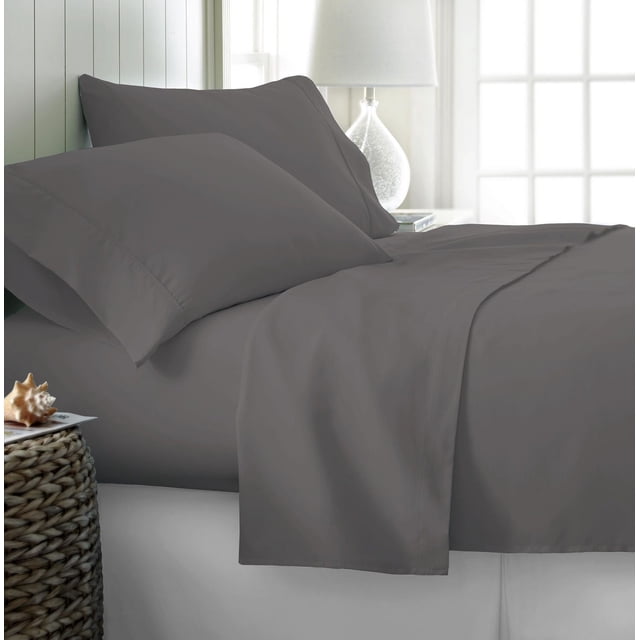 Johnson Home 300 Thread Count Combed Egyptian Cotton Sheet Sets in dark grey on a neatly made bed with two matching pillowcases, featuring smooth, breathable fabric woven from long-staple Egyptian cotton for lasting softness and durability in a softly lit bedroom with a white lamp and window.