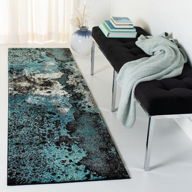 Safavieh Glacier Malanie Tapis Abstrait Mettant en Vedette un long Coureur avec un Poil Doux Tissé Mécaniquement et un Motif Marbré Abstrait en Tons Bleu, Noir et Crème. Il Est Posé sur un Plancher Blanc à Côté d'Un Banc Capitonné Noir avec des Pattes Chromées, Drapé d'Un Jeté Tricoté Bleu Pâle et de Livres Empilés. un vase en Céramique Bleu et Blanc avec des Fleurs Séchées s'Asseoit Près de Voilages Blancs, Soulignant les Qualités Durables et Décoratives du Tapis, Idéal pour les Zones d'Accent.