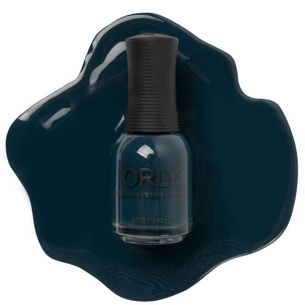 ORLY Nail Lacquer from the Desert Muse Collection in the shade Midnight Oasis, a dark grey-blue crème nail polish. The 0.6oz (18ml) bottle is displayed against a matching dark grey-blue polish spill, highlighting its rich, long-lasting colour.