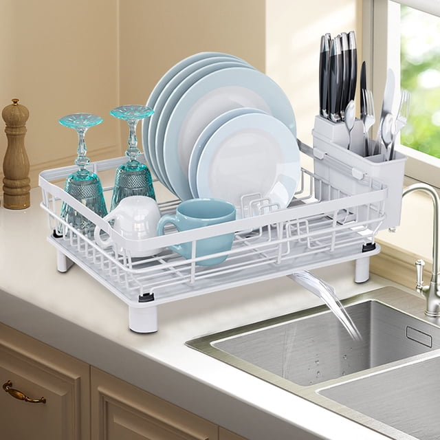 TopLLC Kitchen Accessories multi-functional dish rack in white, designed for kitchen organization and storage. The rack features a compact design with sections for plates, glasses, and utensils, along with a drainage spout directing water into the sink. Made of durable wrought iron, it measures 43x33x15 cm and is suitable for countertops. The rack is shown holding dishes, cups, and cutlery, placed beside a kitchen sink with a beige countertop.