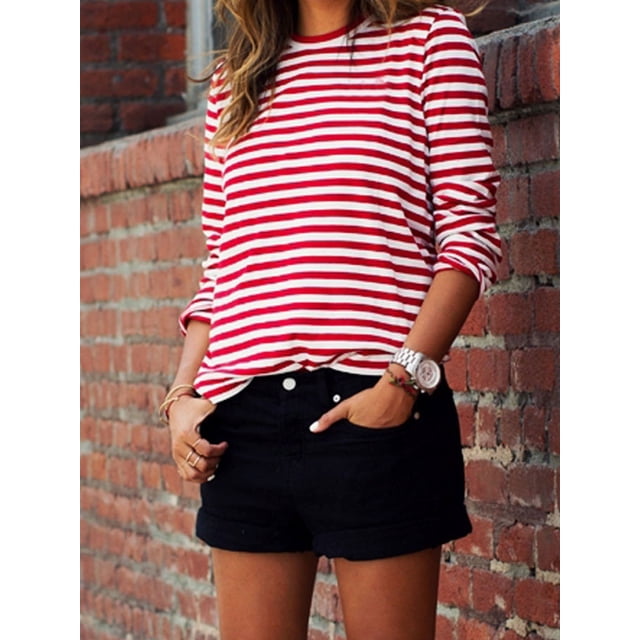 T-shirt à Manches Longues Rayé Rouge et Blanc pour Femmes, en Coton, Coupe Ample avec Encolure O. Le T-Shirt Présente des Rayures Horizontales Rouges et Blanches Audacieuses, des Manches Longues et un style Décontracté Adapté à l'Automne. Montré Assorti à des shorts Noirs dans un Contexte Urbain Extérieur.