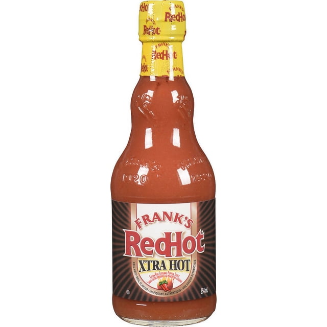 Frank's RedHot Extra Hot 354ml hot sauce bottle with red cayenne pepper sauce inside, yellow cap featuring repeated Frank's RedHot logo, and label highlighting extra hot flavor made from aged cayenne peppers, suitable for adding fiery heat to meals.