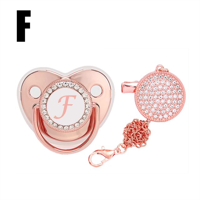 DPTALR Baby Pacifier 26 Letter Name Initial Clip Silicone Infant Nipple Bling Newborn Pacifier in a rose gold finish with rhinestone embellishments. The pacifier features a customizable initial 'F' on the front and includes a matching anti-lost clip with a chain. Made of food-grade silicone, it is safe for infants and designed to comfort babies while supporting oral development. The clip can be attached to clothing or strollers to prevent loss. Suitable as a baby gift for special occasions.