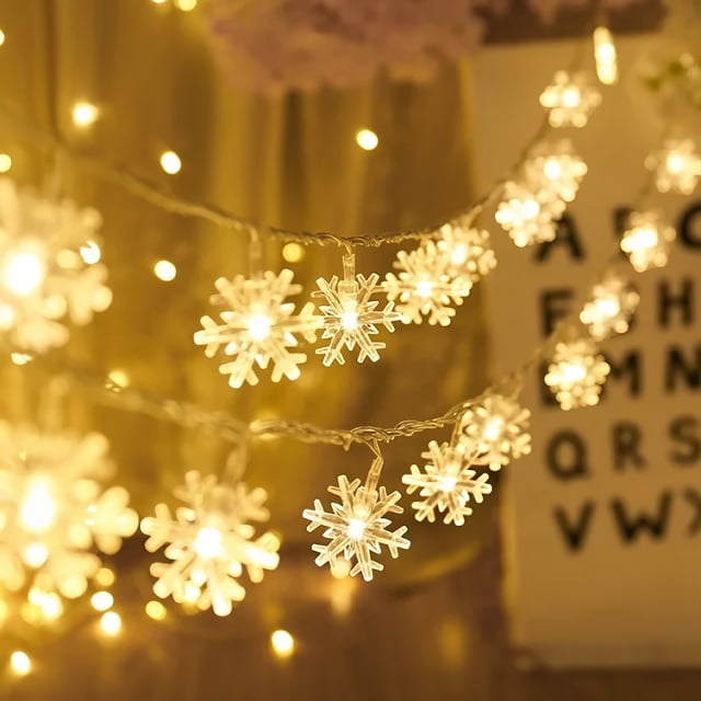 Christmas Snowflake String Lights, 6M battery-operated string lights featuring 40 cool white LED snowflake-shaped lights. The flexible copper wire allows for customizable shapes, and the IP65 waterproof design makes them suitable for indoor and outdoor use. Powered by 3 AA batteries (not included), these lights offer two modes: flickering and steady illumination. Ideal for decorating Christmas trees, bedrooms, or holiday parties.