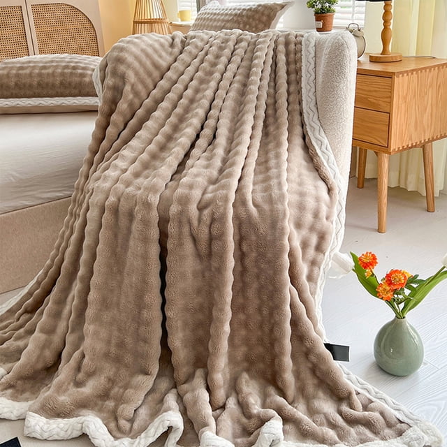 Dvkptbk Woolen Blanket Soft Bubble Fleece Blanket in khaki color, displayed draped over a bed in a cozy bedroom setting. The blanket features a double-sided plush design with a soft bubble texture and white trim, offering warmth and comfort. Ideal for all-season use, it measures 100x150cm (39.3x59in) and is machine washable for easy care.