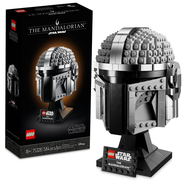LEGO Star Wars The Mandalorian Helmet 75328 building kit with 584 pieces, featuring a detailed replica of The Mandalorian’s helmet in metallic gray drum-lacquered bricks, displayed on a black brick-built stand with a nameplate, shown alongside its box packaging.