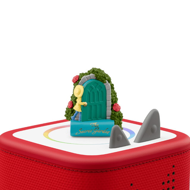 tonies le Jardin Secret Figurine Tonie Représente un Enfant à Capuchon Jaune Ouvrant une Porte Arquée Sarcelle Entourée de Feuillage Vert et de roses Rouges, Debout sur une base Bleue Étiquetée « le Jardin Secret », Placée sur un Lecteur audio Toniebox Rouge avec des Oreilles Grises, Convient pour Raconter des Histoires Sans Écran et des Aventures Imaginatives.
