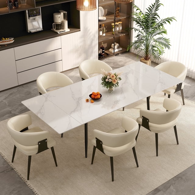 NessCarsti Table de Salle à Manger Extensible avec Plateau en Pierre Frittée Blanche, Présentée dans un Décor de Salle à Manger Moderne. la Table Mesure 62,9 Pouces et s'Étend jusqu'à 94,5 Pouces, Pouvant Accueillir de 6 à 10 Personnes. Elle Présente une base Robuste en Acier Inoxydable 304 et en Acier au Carbone, Supporte jusqu'à 1100 Lb. le Plateau Est Résistant au Feu et à la Chaleur, Résistant aux Égratignures et Facile à Nettoyer. la Table s'Agence à six Chaises de Couleur Crème