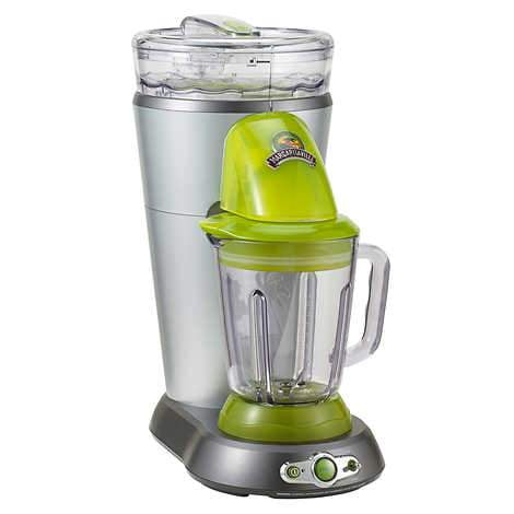 Margaritaville Bahamas Frozen Concoction Maker with Travel Bag, a countertop blender with a white finish and key lime accents. Features a shatterproof plastic blending jar, an ice reservoir, and manual shave and blend controls. Creates 1 L (4 cups) of frozen drinks with 450 W of combined shaving and blending power. Includes a premium travel bag with reinforced padded base and foam-padded interior for storage and portability.