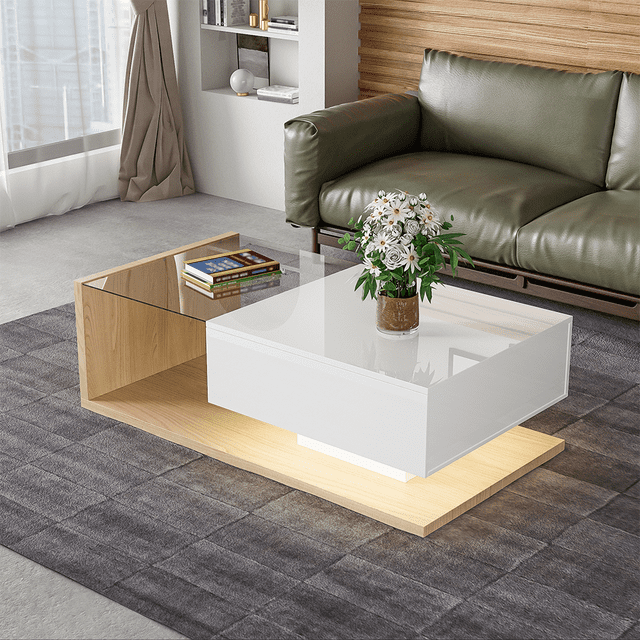 Modern coffee table with tempered glass and a high-gloss UV surface, featuring a two-tier design with LED lighting. The table combines a white and natural wood finish, with a 5mm tempered glass top for durability and a smooth, waterproof surface for easy cleaning. It includes a sturdy wooden structure and a drawer with metal glides for smooth operation. The table is displayed in a contemporary living room setting, placed on a grey rug with a green sofa in the background.