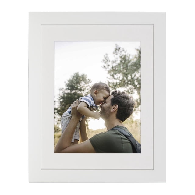 hometrends Museum White Picture Frame featuring a wide white profile and optional white mat holding an 11 by 14 inch photo of a man lifting a child outdoors with trees in the background, designed for easy horizontal or vertical wall display and suitable for creating gallery walls.