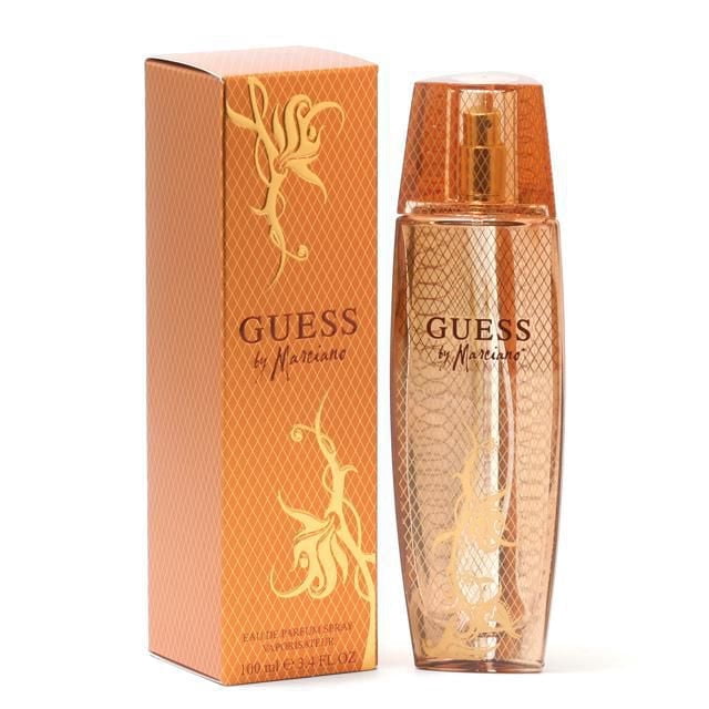 Guess Marciano Eau De Parfum Spray For Women 100ml in a slender amber glass bottle with gold floral detailing and an amber cap, next to its orange box with a diamond pattern and gold floral design, ideal for daily wear and gifting.