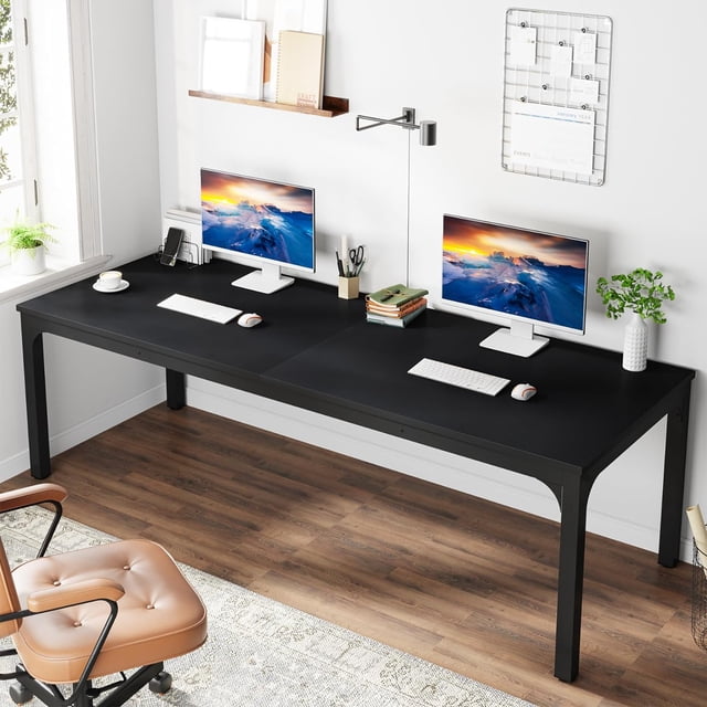 Tribesigns 78.7 Inches Extra Long Computer Desk designed for two-person use, featuring a black industrial-style design with a spacious 78.7-inch wide and 27.5-inch deep desktop. The desk is constructed with a 0.59-inch thick MDF board and sturdy powder-coated iron pipe legs, supporting up to 200 lbs. The setup includes two monitors, keyboards, and accessories, showcasing its functionality in a home office setting with a wood floor and white walls.