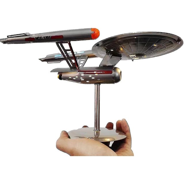 U.S.S. Enterprise Star Trek Modèle NCC-1701 Réplique en Acier Inoxydable, avec Détails Complexes et Lumières DEL. le Modèle Mesure 30 x 15 x 20 cm (11,81 x 5,90 x 7,87 Pouces) et Est Exposé sur un Support Ajustable. Il Est Montré Tenant à la Main, Mettant en Valeur Sa Conception Compacte et Légère. Convient à la Décoration de la Maison, à une collection Ou comme Cadeau pour les fans de Star Trek.