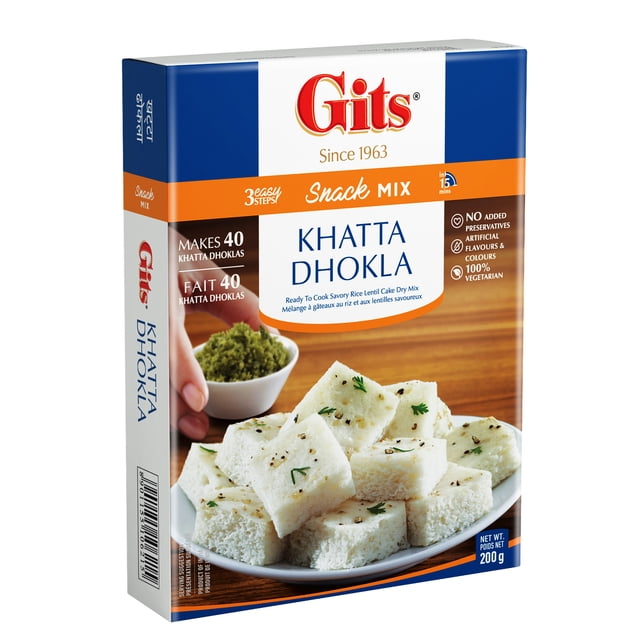 Gits Khatta Dhokla Instant Mix 200g box showing a plate of soft, spongy white dhokla cubes garnished with mustard seeds and cilantro, with a small bowl of green chutney on a wooden surface, highlighting the ready-to-cook, preservative-free, 100% vegetarian Indian snack mix.