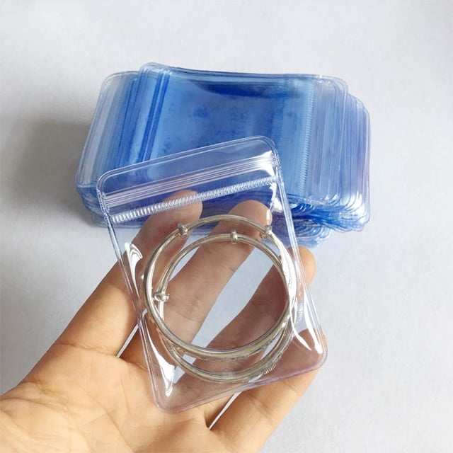 100 Pack PVC Clear Jewelry Anti Oxidation Zipper Bag Antitarnish Plastic Bags for Packaging Jewelry Rings Earrings Transparent Poly Pouch in light blue color, measuring 2.75×3.93 inches. Made of durable PVC material with a reclosable zipper lock, these bags prevent oxidation and protect items from moisture, dust, and bacteria. Suitable for storing jewelry, jade, earrings, rings, pearls, crafts, and small gifts. The clear design allows easy visibility of contents.