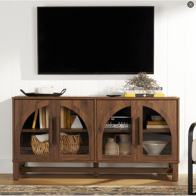 Better Homes & Gardens Meuble Télé Juliet Arc pour Téléviseurs jusqu'à 65 Pouces avec Bois Foncé, Portes en Verre Trempé Arquées et Deux Tablettes Ajustables pour Tenir des Livres, des Paniers Tressés, des vases en Céramique et des Bols Décoratifs, Placé sous un Téléviseur à Écran Plat Mural sur un Mur à Panneaux Blancs, Idéal pour le Rangement et l'Exposition de Médias.