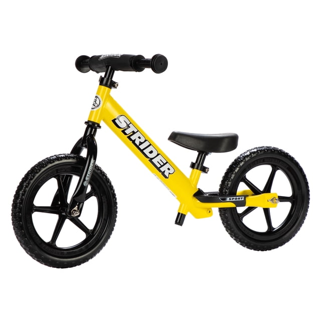 Strider - 12 Sport Balance Bike in yellow, designed for children aged 18 months to 5 years. Features a lightweight steel frame weighing 3.0 kg (6.7 lbs.), flat-free foam rubber tires, and an ergonomically padded seat. Includes mini-grips for small hands, an extra-long seatpost for growth, and a built-in footrest for balance. The bike has easy-adjust clamps for seat and handlebar adjustments and a handlebar safety pad for added protection.