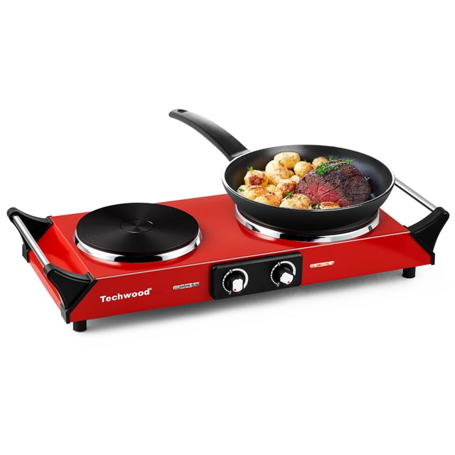 Techwood 1800W Double Burner Electric Hot Plate with a red stainless steel design, featuring two 7.5-inch heating surfaces and adjustable temperature dials. One burner is in use with a frying pan containing steak and potatoes. The unit includes stay-cool handles and non-slip feet, ideal for small kitchens, dorms, RVs, or camping.