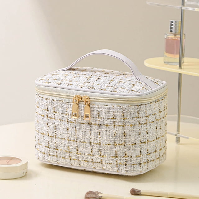 EGNMCR Closet Organizers and Storage, large capacity makeup bag with a textured white and gold exterior, featuring a sturdy handle and smooth dual zipper closure. Ideal for travel, daily use, and organizing cosmetics, toiletries, and small essentials. Displayed on a beige tabletop with makeup brushes and cosmetics nearby.