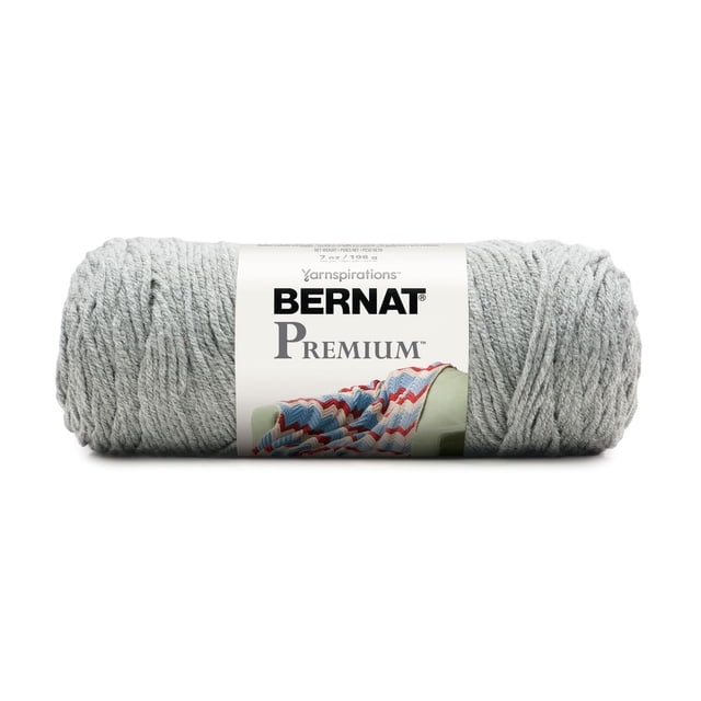 Bernat® Premium TM Fil, Acrylique #4 Moyen, 7oz/198g, 360 Yards en Gris Pâle, Montré Orienté vers l'Avant avec une Étiquette Blanche Présentant le logo Bernat Premium et une image d'Un afghan Tricoté Multicolore sur un Fauteuil Vert, Fait de Fil Acrylique Ultra Doux de Poids Moyen avec une Torsade Subtile à 4 Brins, Convient aux Projets de Tricot et de crochet Incluant des afghans et des Vêtements.