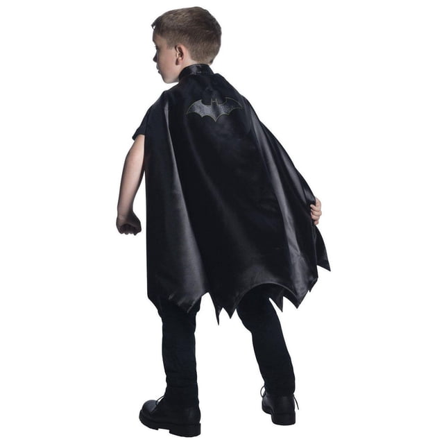 Deluxe Batman Boy's Cape shown from the back on a child, made of black satin polyester with a black embroidered Batman emblem on the upper back and a jagged hemline, designed as a Halloween costume accessory.