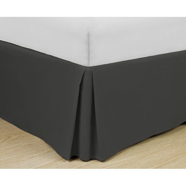 Jupe de Lit en Microfibre Super Douce Grisée Montrée dans un Gros Plan d'Angle avec design à Plis Caissons sur Mesure et Tissu en Microfibre Résistant aux Plis, Ajustée sous un Matelas Blanc sur un Plancher de Bois Clair, Idéale pour Rehausser la Déco de la Chambre et Offrir une Finition Soignée.