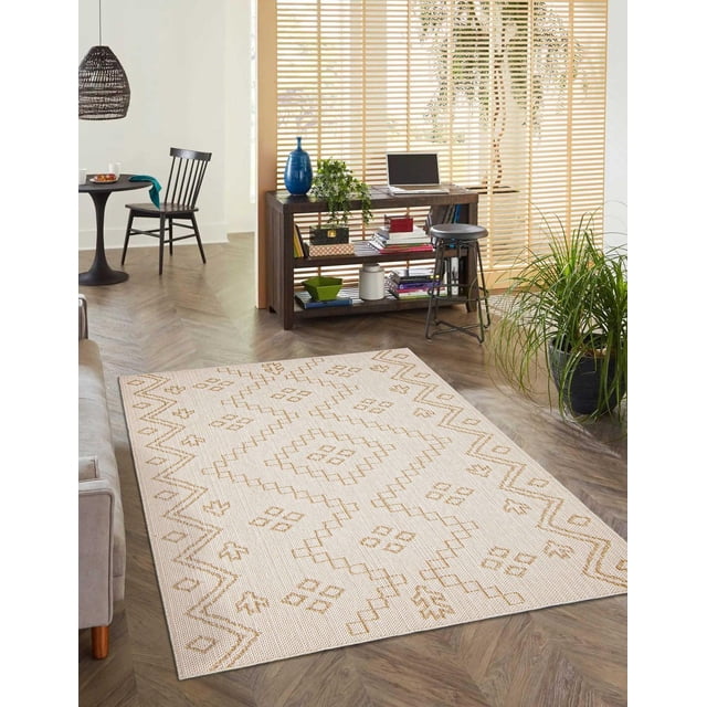 ECARPET Tapis Style Jute pour Chambre, Salon, Salle à Manger Caral Collection en beige avec Motifs Géométriques beige sur Planchers de Bois Franc. Positionné Près d'Un sofa Gris, console en Bois avec Livres et Déco, Tabouret en Métal Noir, et une Grande Plante Verte. Convient aux Espaces Intérieurs Très Passants et Complète des Intérieurs Côtiers Ou Campagnards.
