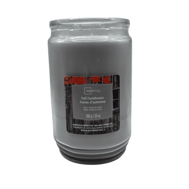MAINSTAYS PL Fall Farmhouse Scented Single-Wick Glass Jar Candle, 20 oz, front-facing with grey wax in a clear glass jar featuring a label with spice, cypress, and amber scent notes, ideal for seasonal home décor and creating a relaxing atmosphere.
