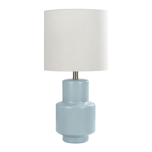 HOMETRENDS Table Lamp with a light blue ceramic base featuring a modern geometric silhouette and an oatmeal linen drum shade, standing 24 inches tall with a rotary switch, suitable for bedrooms, offices, or living rooms.