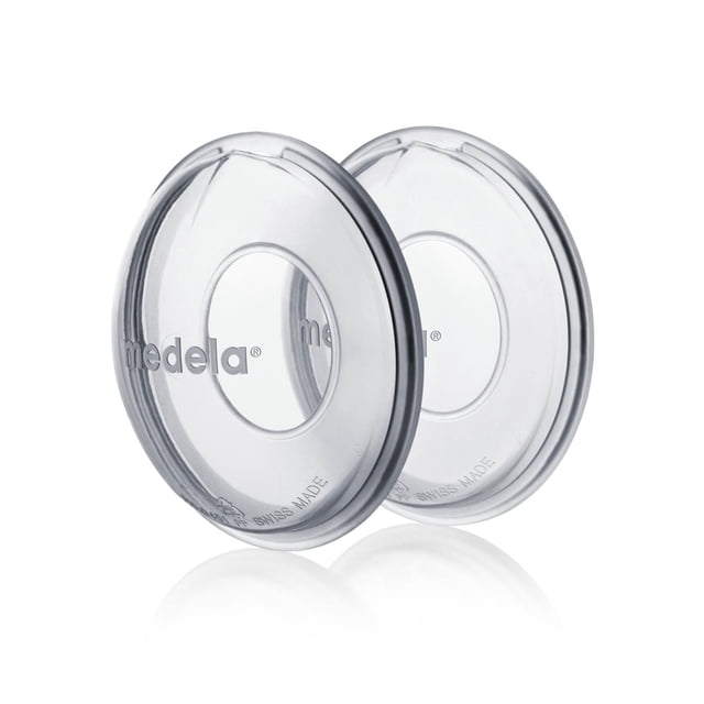 Medela Breast Milk Collection Shells shown as two clear, flexible silicone shells with central openings and the Medela logo, designed to fit the breast and collect excess milk during breastfeeding or pumping. They feature a spill-free spout for easy pouring, are BPA-free, dishwasher safe, and discreet for wearing under clothing to protect sensitive skin.