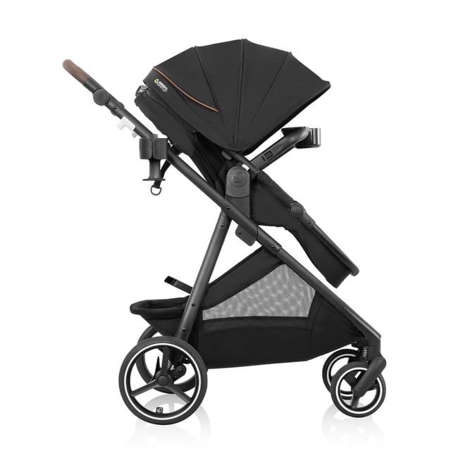 Evenflo Shyft Intuiti+ Stroller with Green & Gentle Fabric in black, side profile showing a modular frame with all-wheel suspension, expandable canopy, adjustable leatherette handle, mesh storage basket, and four rubber tires for smooth maneuvering.