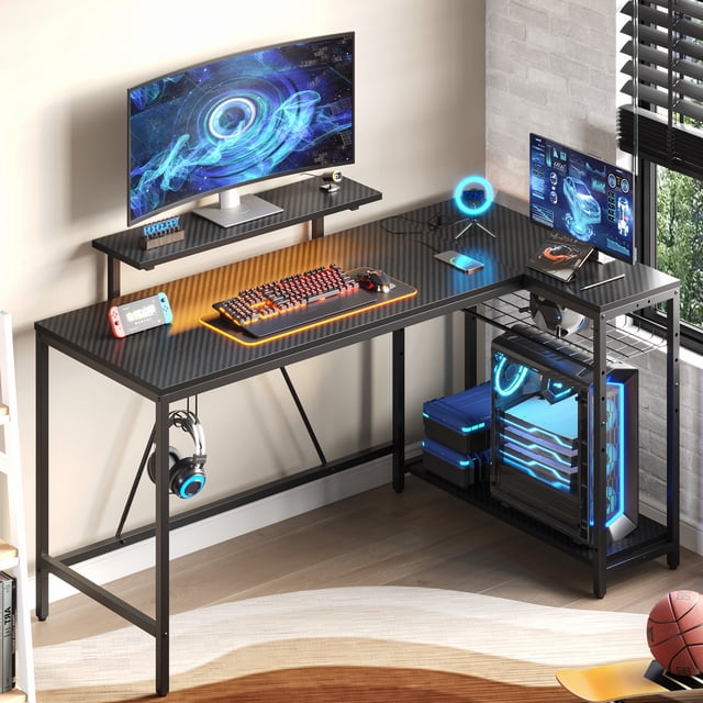 Bestier L Shaped Gaming Desk with LED Lights & Power Outlets, 58'' Reversible Computer Corner Desk with Shelves in carbon fiber black. The desk features a spacious L-shaped design with a removable monitor stand, RGB LED light strip with 7 colors and 20 modes, and 3 AC outlets with 2 USB ports for charging devices. Includes 3-tier storage shelves, a headphone hook, and adjustable feet for stability. Ideal for gaming or home office setups.